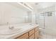 Well-lit bathroom with double sinks, a shower-tub combo, and a glass-blocked window at 5517 Whiteleaf Ct, Las Vegas, NV 89149