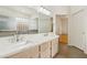 Bright bathroom featuring double sinks with a stone countertop, tiled floors, and white cabinets at 5517 Whiteleaf Ct, Las Vegas, NV 89149