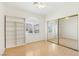 Bright bedroom with a ceiling fan, hardwood floors, built-in shelving, and mirrored closet doors at 5517 Whiteleaf Ct, Las Vegas, NV 89149