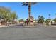 Gated community entrance featuring desert landscaping, a guard house, and mature palm trees at 5517 Whiteleaf Ct, Las Vegas, NV 89149