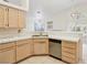 Bright kitchen featuring tile countertops, stainless steel dishwasher, and natural wood cabinetry at 5517 Whiteleaf Ct, Las Vegas, NV 89149