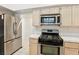 Bright kitchen featuring stainless steel appliances and tile countertops at 5517 Whiteleaf Ct, Las Vegas, NV 89149