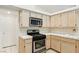 Close up of eat-in kitchen featuring stainless steel appliances, white cabinets, and tiled countertops at 5517 Whiteleaf Ct, Las Vegas, NV 89149