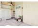 Enclosed patio featuring dual white metal security doors, overhead fan, and neutral color scheme with various potted plants at 5517 Whiteleaf Ct, Las Vegas, NV 89149