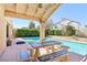 Inviting backyard oasis with a covered patio, tiled table with benches, lush landscaping and private pool at 5517 Whiteleaf Ct, Las Vegas, NV 89149