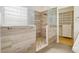 Bright shower featuring brown tiled walls, stone flooring, and a glass partition at 5517 Whiteleaf Ct, Las Vegas, NV 89149