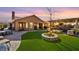 Expansive backyard featuring a covered patio, lush lawn, and elegant stone landscaping at 6316 Canyon Ridge Dr, Las Vegas, NV 89108