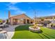 A beautiful backyard featuring a covered patio, artificial grass, and a paved seating area, perfect for outdoor entertaining at 6316 Canyon Ridge Dr, Las Vegas, NV 89108