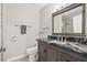 Bathroom with a dark vanity with granite counters, a toilet, and a mirror with a dark wood frame at 6316 Canyon Ridge Dr, Las Vegas, NV 89108