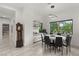 Bright dining room features a modern chandelier, a stylish table, and a large window with a verdant outdoor view at 632 Canyon Greens Dr, Las Vegas, NV 89144