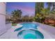 Backyard pool features a spa and water feature, set against a backdrop of lush greenery and a vibrant sunset at 632 Canyon Greens Dr, Las Vegas, NV 89144