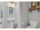 Powder room features a pedestal sink, mirror, and toilet with shelf for decor at 6489 Little Harbor Ct, Las Vegas, NV 89141