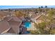 Aerial view of community pool and hot tub, surrounded by well-maintained homes and palm trees at 701 Aztec Cir, Mesquite, NV 89027