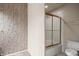 Bathroom featuring floral wallpaper, white tile, and gold-framed shower at 701 Aztec Cir, Mesquite, NV 89027