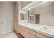 Bathroom featuring double sinks, large mirror, and door to laundry at 701 Aztec Cir, Mesquite, NV 89027