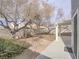 Large backyard featuring mature trees, rock landscaping, and covered patio at 7117 Shadow Crest Dr, Las Vegas, NV 89119