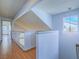 Bright hallway with wood floors and a modern chandelier near an upstairs window at 7117 Shadow Crest Dr, Las Vegas, NV 89119