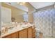 Bathroom vanity with cabinets, mirror, sink, and bathtub-shower combo at 7433 Calzado Dr, Las Vegas, NV 89178