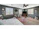 View of a bedroom with gray walls, large windows, ceiling fan, and carpeted floor at 7433 Calzado Dr, Las Vegas, NV 89178