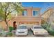 Charming two-story home with a two-car garage and desert landscaping, with two cars parked outside at 7433 Calzado Dr, Las Vegas, NV 89178