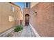 Inviting front entry with a arched entryway, leading to a dark wood front door and landscaped walkway at 7433 Calzado Dr, Las Vegas, NV 89178