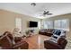 Inviting living room featuring hardwood floors, large windows, and a plush leather sectional at 7433 Calzado Dr, Las Vegas, NV 89178