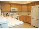 Functional kitchen featuring a white refrigerator, range, microwave and light wood cabinetry at 7950 W Flamingo Rd # 1139, Las Vegas, NV 89147