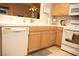 Kitchen featuring white dishwasher, tile countertops, and natural wood cabinets at 7950 W Flamingo Rd # 1139, Las Vegas, NV 89147