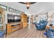 Comfortable living room with wood-look flooring, large TV, and ceiling fan at 8404 Bay Crest Dr, Las Vegas, NV 89128