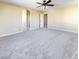 Large bedroom with neutral carpeting, ceiling fan, and attached bathroom at 8452 Viansa Loma Ave, Las Vegas, NV 89149