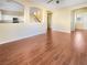 Open-concept living room featuring wood floors and seamless access to the kitchen and staircase at 8452 Viansa Loma Ave, Las Vegas, NV 89149