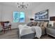 Bright bedroom featuring a large window, modern light fixture, and comfortable furnishings at 10852 Avenzano St, Las Vegas, NV 89141