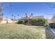 The backyard boasts green grass, mature shrubbery, and a covered patio at 1716 Battle Creek Cir, Las Vegas, NV 89108