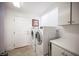 Functional laundry room equipped with a washer, dryer, and plenty of storage space at 204 N Ring Dove Dr, Las Vegas, NV 89144