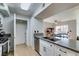 Open kitchen features white cabinetry, gray countertops, stainless appliances, and a laundry closet at 2300 E Silverado Ranch Blvd # 2162, Las Vegas, NV 89183