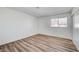 Well-lit bedroom featuring wood-look flooring, neutral walls, and a window allowing natural light to fill the room at 2333 Wooster Cir # B, Las Vegas, NV 89108