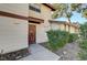 Close-up of a front door with a wooden frame, accompanied by trimmed greenery and a well-kept walkway at 2333 Wooster Cir # B, Las Vegas, NV 89108