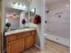 Bathroom featuring a granite countertop, wood cabinets, and tiled walk-in shower at 2451 Muirfield Ave, Henderson, NV 89074