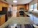 Stainless steel appliances, tile floors, granite counters and light wood cabinets in kitchen at 2451 Muirfield Ave, Henderson, NV 89074
