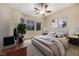 Comfortable bedroom with a ceiling fan, two large windows, and neutral colors and wood floors at 2725 Cool Lilac Ave, Henderson, NV 89052