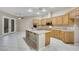 Bright kitchen featuring an island, tile flooring, wood cabinets, and stainless steel appliances at 2725 Cool Lilac Ave, Henderson, NV 89052