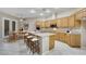 Spacious kitchen with an island, bar seating and wood cabinets, next to breakfast nook at 2725 Cool Lilac Ave, Henderson, NV 89052