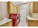 Bright laundry room with red front-loading washer and dryer and plenty of cabinet storage at 2725 Cool Lilac Ave, Henderson, NV 89052