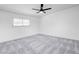 Bright bedroom features plush gray carpet, ceiling fan, and a window for natural light at 3511 Blackstone St, Las Vegas, NV 89121