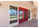 Covered back patio featuring red french doors, neutral siding, and brick-look flooring, perfect for outdoor relaxation at 3665 S Pointe Cir, Laughlin, NV 89029