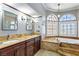 Bathroom with a soaking tub, double sinks, dark wood cabinetry and granite countertops at 3665 S Pointe Cir, Laughlin, NV 89029