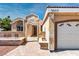 Close up view of stucco home's front exterior showcasing a two-car garage and stone accents along the front at 3665 S Pointe Cir, Laughlin, NV 89029