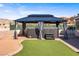 Backyard gazebo featuring a hot tub, artificial turf, and surrounding landscape, creating a relaxing outdoor retreat at 3665 S Pointe Cir, Laughlin, NV 89029