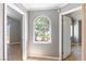 Bright hallway with beautiful arched window, neutral paint, tile floor, and white trim at 3665 S Pointe Cir, Laughlin, NV 89029