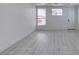 Bright living room boasts sleek floors, baseboard trim, two windows, and a door with black hardware at 3721 Brentcove Dr, North Las Vegas, NV 89032